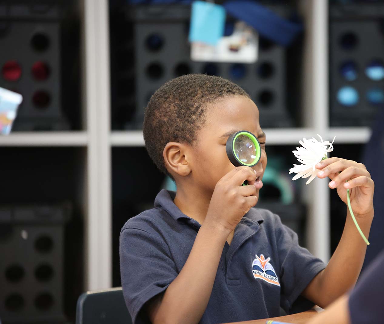 Student working on a notebook in a classroom.